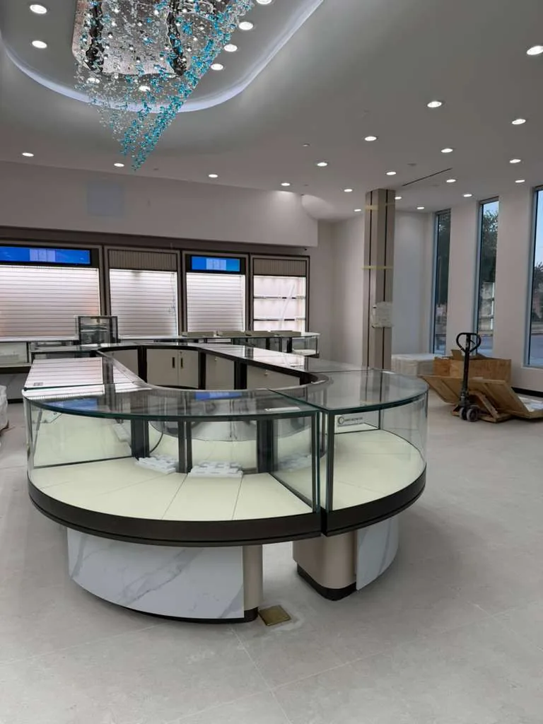 Curved island display case with lit wall bays behind