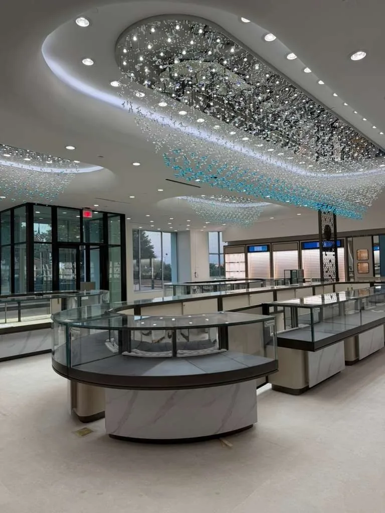 Showroom with curved glass display cases under a crystal feature ceiling